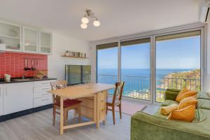 a kitchen and dining room with a view of the ocean at Studio SeaSky Tabua by Holiday Rental Madeira in Ribeira Brava