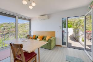 a living room with a table and a couch at Studio SeaSky Tabua by Holiday Rental Madeira in Ribeira Brava