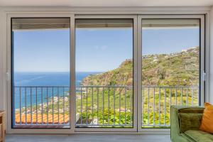 a living room with a view of the ocean at Studio SeaSky Tabua by Holiday Rental Madeira in Ribeira Brava +8 photos