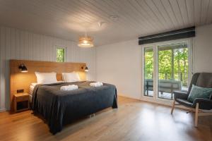 a bedroom with a bed and a chair and a window at Stay North - Peikkola in Kirkkonummi