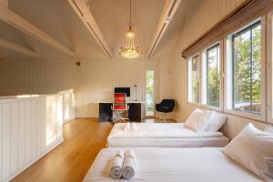 a bedroom with two beds and a desk in it at Stay North - Peikkola in Kirkkonummi