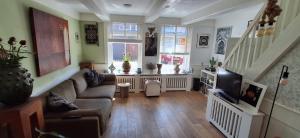a living room with a couch and a tv at Viking in Egmond aan Zee