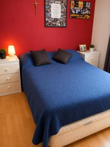 a bedroom with a blue bed with a red wall at EXPONOR 2026 Casa 3D 2B in Antofagasta