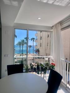 a dining room with a table and a view of the ocean at Apartamento Blanco Albir in Albir