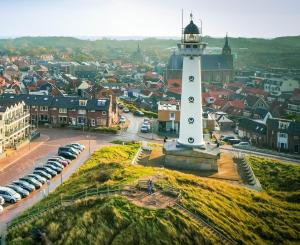 a lighthouse in the middle of a city at Viking in Egmond aan Zee +4 photos