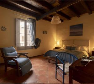 a bedroom with a bed and a chair and a window at Le Case di Sottovento in Mola di Bari