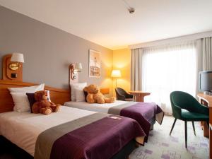 zwei Teddybären sitzen auf zwei Betten in einem Hotelzimmer in der Unterkunft Mercure Cieszyn in Cieszyn + 237 Fotos