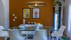 a dining room with a glass table and white chairs at Villa NoYa in Oualidia