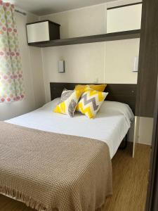 a bedroom with a bed with yellow and white pillows at Camping benquerencia in Pena +5 photos