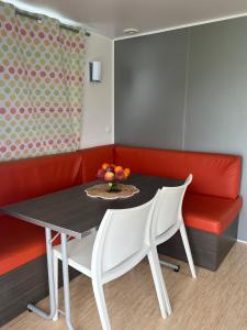 a table with two white chairs and a red couch at Camping benquerencia in Pena