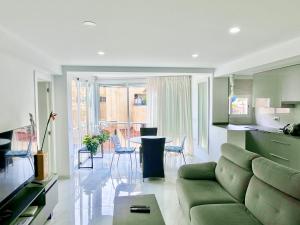 a living room with a green couch and a table at Apartamento Blanco Albir in Albir