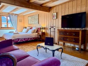 a bedroom with a bed and a flat screen tv at L'Héritage 1779 in Duntzenheim