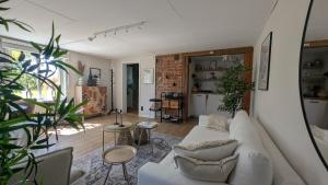 a living room with a white couch and some plants at Dagöholm Gård in Valla