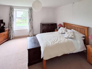 a bedroom with a large bed and a window at Lilac Cottage in Hawes +8 photos