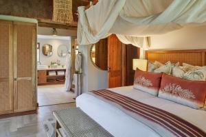 a bedroom with a bed and a bathroom at Taj Bush Lodge in Hoedspruit +47 photos