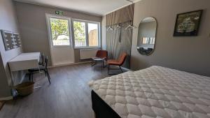 a bedroom with a bed and a sink and a desk at Dagöholm Gård in Valla
