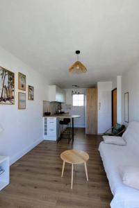 a living room with a white couch and a table at Le cocon de Marennes in Marennes