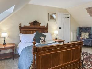 a bedroom with a bed with a teddy bear sitting on it at Foumartdean Cottage in Town Yetholm