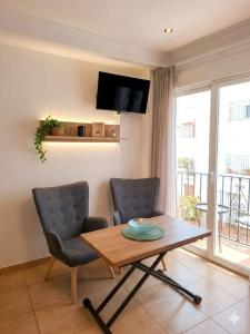 a living room with a table and a chair at Apartamentos El Barrio in Nerja