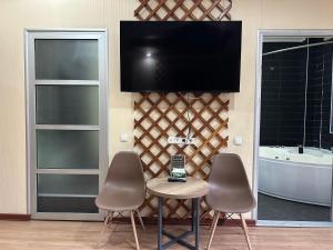 a room with two chairs and a table and a tv at Gatsby Ortosay in Orto-Say