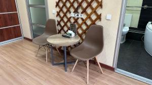 a table with four chairs and a phone on it at Gatsby Ortosay in Orto-Say