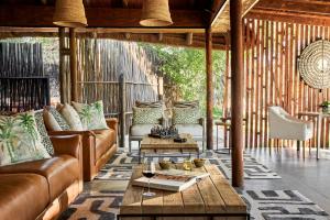 a living room with a couch and a table at Taj Bush Lodge in Hoedspruit