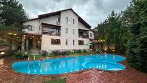 a swimming pool in front of a house at Gatsby Ortosay in Orto-Say