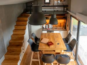 a small kitchen and dining room with a table and chairs at Gemütliches Tiny House zwischen zwei Naturteichen - Kamin, Terrasse & Natur pur in Lauterbach