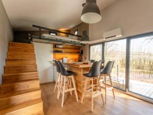 a kitchen with a wooden table and chairs at Gemütliches Tiny House zwischen zwei Naturteichen - Kamin, Terrasse & Natur pur in Lauterbach