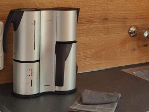 a coffee maker sitting on top of a counter at Gemütliches Tiny House zwischen zwei Naturteichen - Kamin, Terrasse & Natur pur in Lauterbach +18 photos