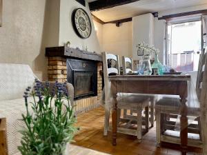 a living room with a table and a fireplace at Studio de charme in Breil-sur-Roya