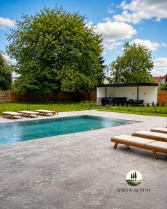 a swimming pool with benches and a building at Villa-Vista di Pini Sarajevo in Sarajevo