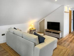 a living room with a couch and a flat screen tv at Gatherley Loft in Scorton