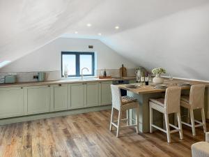 a kitchen with a table and chairs and a sink at Gatherley Loft in Scorton
