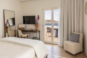 a bedroom with a bed and a desk and a balcony at Casa Kiku Mykonos in Mikonos +63 photos