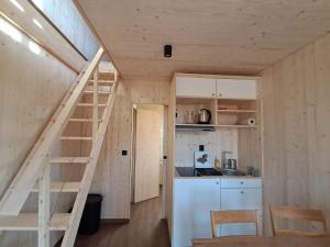 a small kitchen with a staircase in a tiny house at écolodge Aubépine in Leimbach