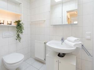 a white bathroom with a toilet and a sink at Apartment Jan im Dangaster Nest in Varel