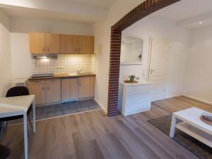 a kitchen with wooden cabinets and a table in a room at Apartment Jan im Dangaster Nest in Varel