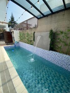 a swimming pool with a water fountain in it at Casa Buenafe in Antipolo