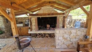 an outdoor room with a stone fireplace in a house at 4Rest Villa in Novalja