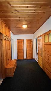 a room with wooden doors and a room with a table at Chalupa pri potoku in Zuberec
