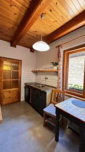 a kitchen with a table and a stove at Chalupa pri potoku in Zuberec