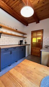 a kitchen with blue cabinets and a wooden floor at Chalupa pri potoku in Zuberec