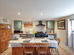 a kitchen with a table with four chairs around it at The Old Tack Room - Uk49233 in Tilshead