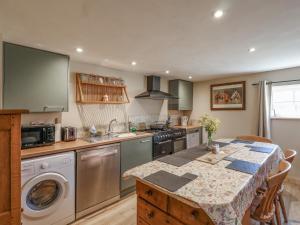 a kitchen with a table and a stove top oven at The Old Tack Room - Uk49233 in Tilshead