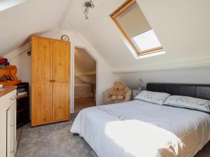 a bedroom with a large bed with a teddy bear at The Old Tack Room - Uk49233 in Tilshead +15 photos