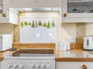 a kitchen with a window with christmas trees on it at Gardeners Cottage in Putley +8 photos