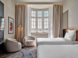 a hotel room with two beds and a window at Mövenpick Grand Hotel Wroclaw in Wrocław