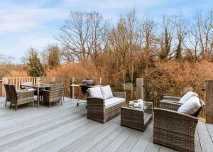 a deck with wicker chairs and a table and a grill at The Astbury Golf And Lodge Resort in Bridgnorth +255 photos