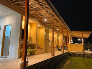 a porch of a house with a hammock on it at Wavez Lombok Hostel in Selong Belanak +6 photos
